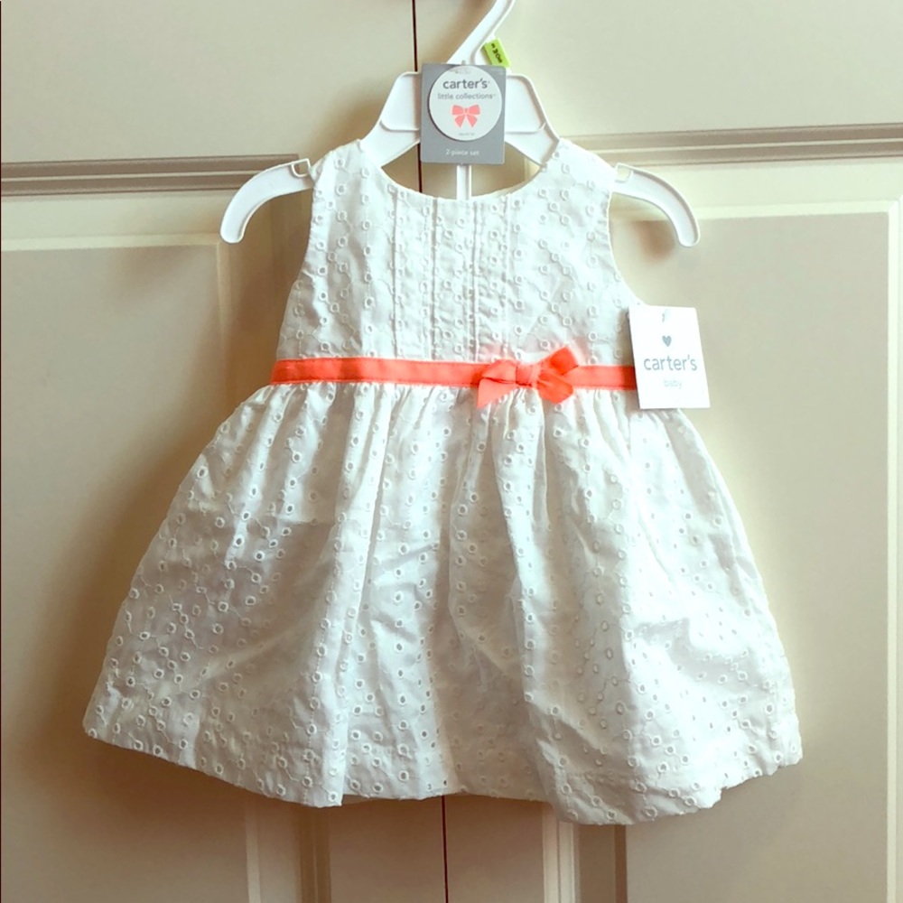 White eyelet dress with orange bow detail.